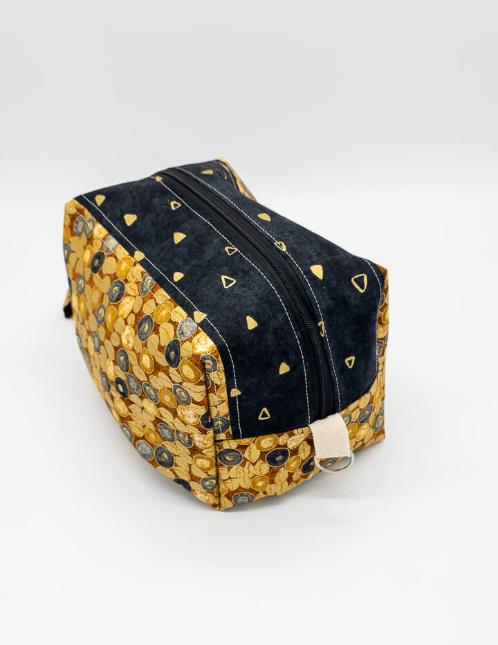 Obere Perspektive der Fenja Bag Midnight Gold mit glattem Reißverschluss und schickem Design.