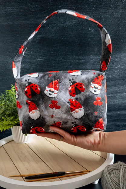 Stricktasche mit praktischem Tragegriff und originellem Glücksmotiv auf dunkelgrauem Baumwollstoff.

