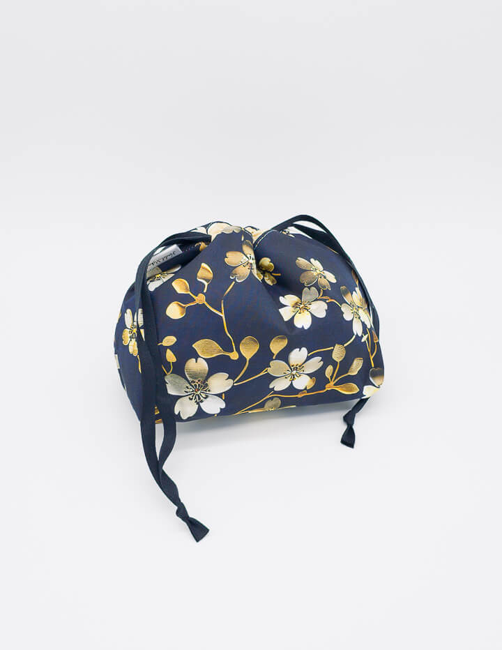 Goldene Blüten auf dunkelblauem Stoff als elegantes Design-Highlight der Lyra Bag.