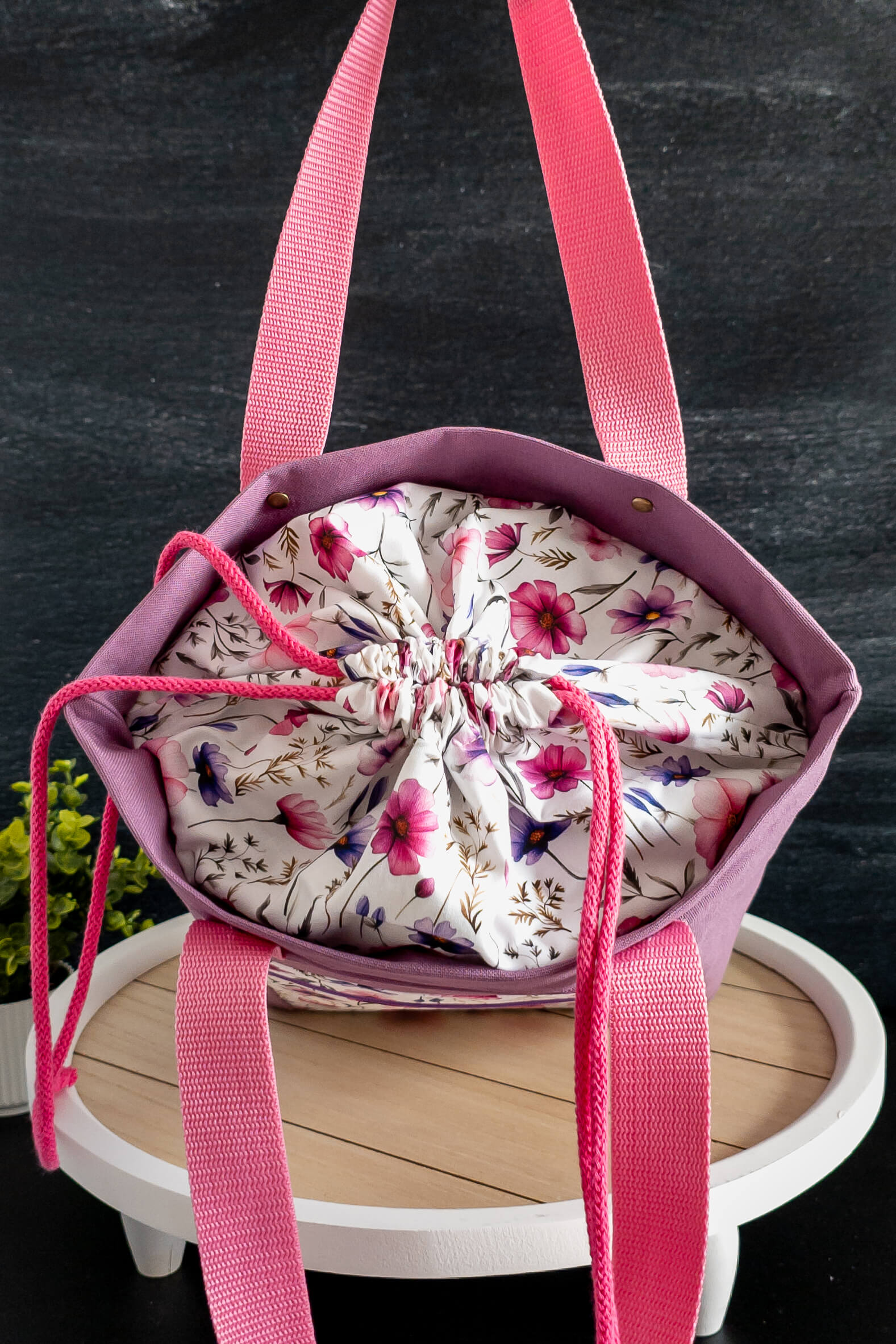 Nahaufnahme des floralen Baumwollstoffs mit lila und pinken Blüten, verleiht der Tasche einen eleganten Look.