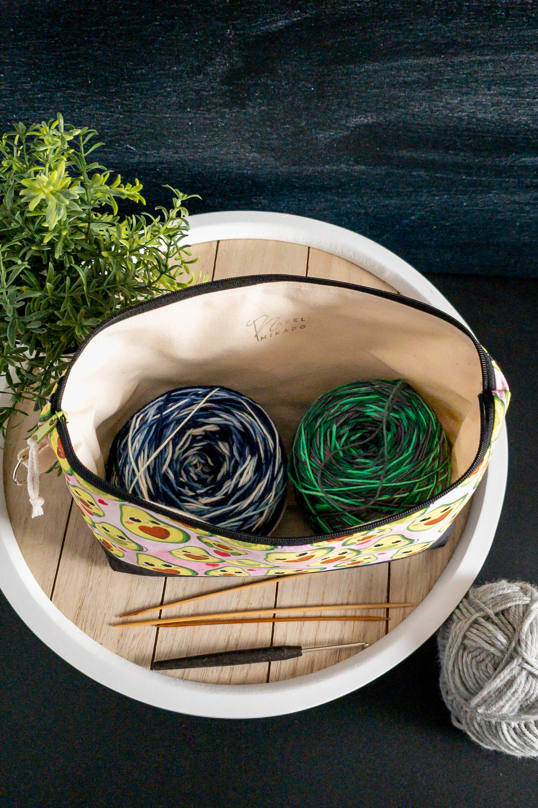Stricktasche auf einem Tablett mit Garnknäuel und Nadeln – gemütliche Atmosphäre für DIY-Momente.
