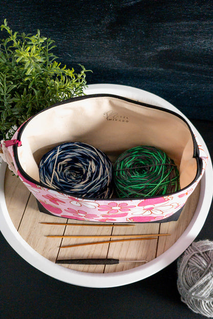 asche auf einem Holztisch dekoriert mit Wolle, Stricknadeln und Pflanzen, ideal für kreative Momente