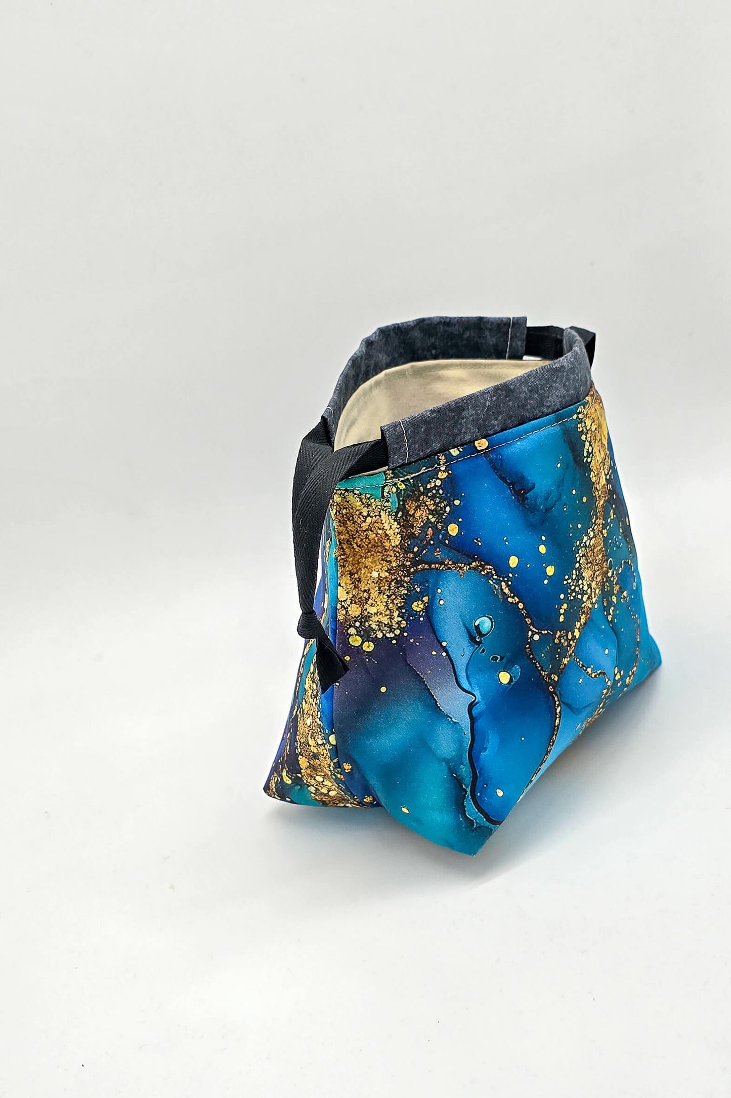 Die Lyra Bag „Ocean Gold“ steht offen, bereit für bis zu 100 g Wolle – ideal für Sockenstricken unterwegs.