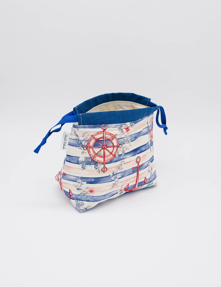 Detailaufnahme der Lyra Bag mit maritimen Motiven und Tunnelzugverschluss aus blauen Bändern.