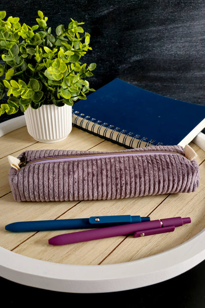 Handgenähte Stiftetasche aus lila Cordstoff mit Reißverschluss auf einem Holztablett