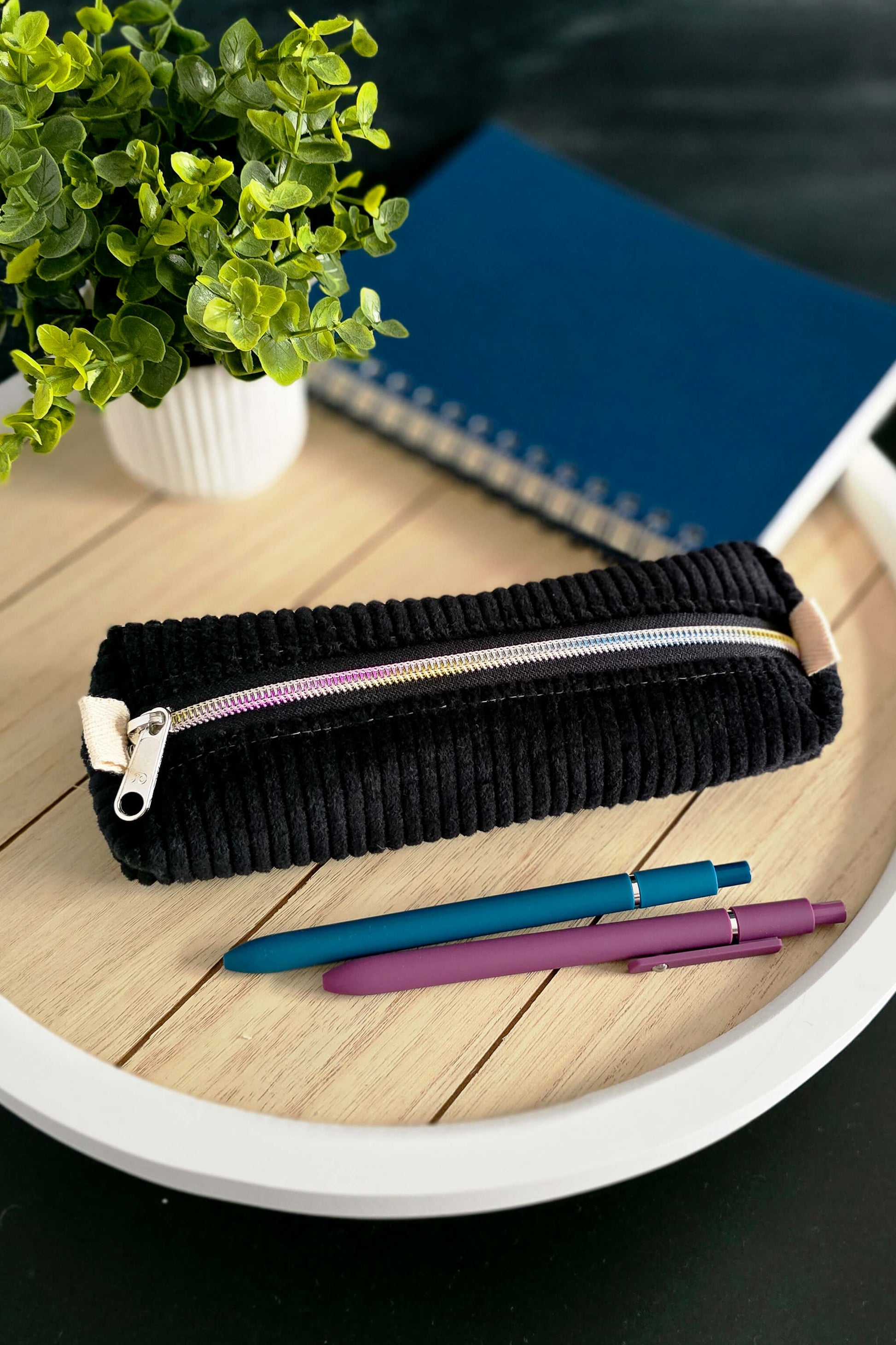 Handgenähte Stiftetasche aus schwarzem Cord mit buntem Reißverschluss auf Tablett dekoriert