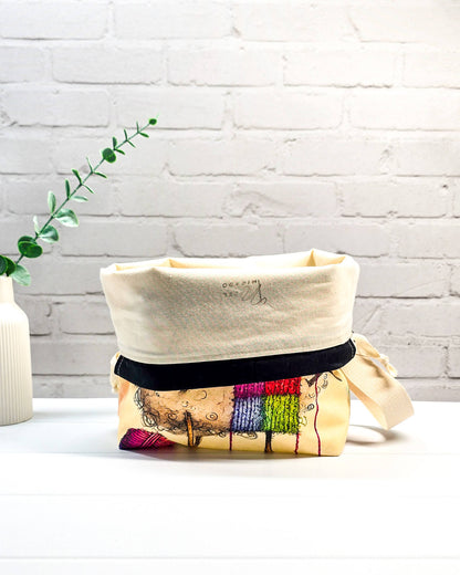Stricktasche mit strickendem Schaf, bunter Mütze, Stricknadeln und Wollknäuel auf hellem Grund, handgenäht in Bayern von NadelMikado.