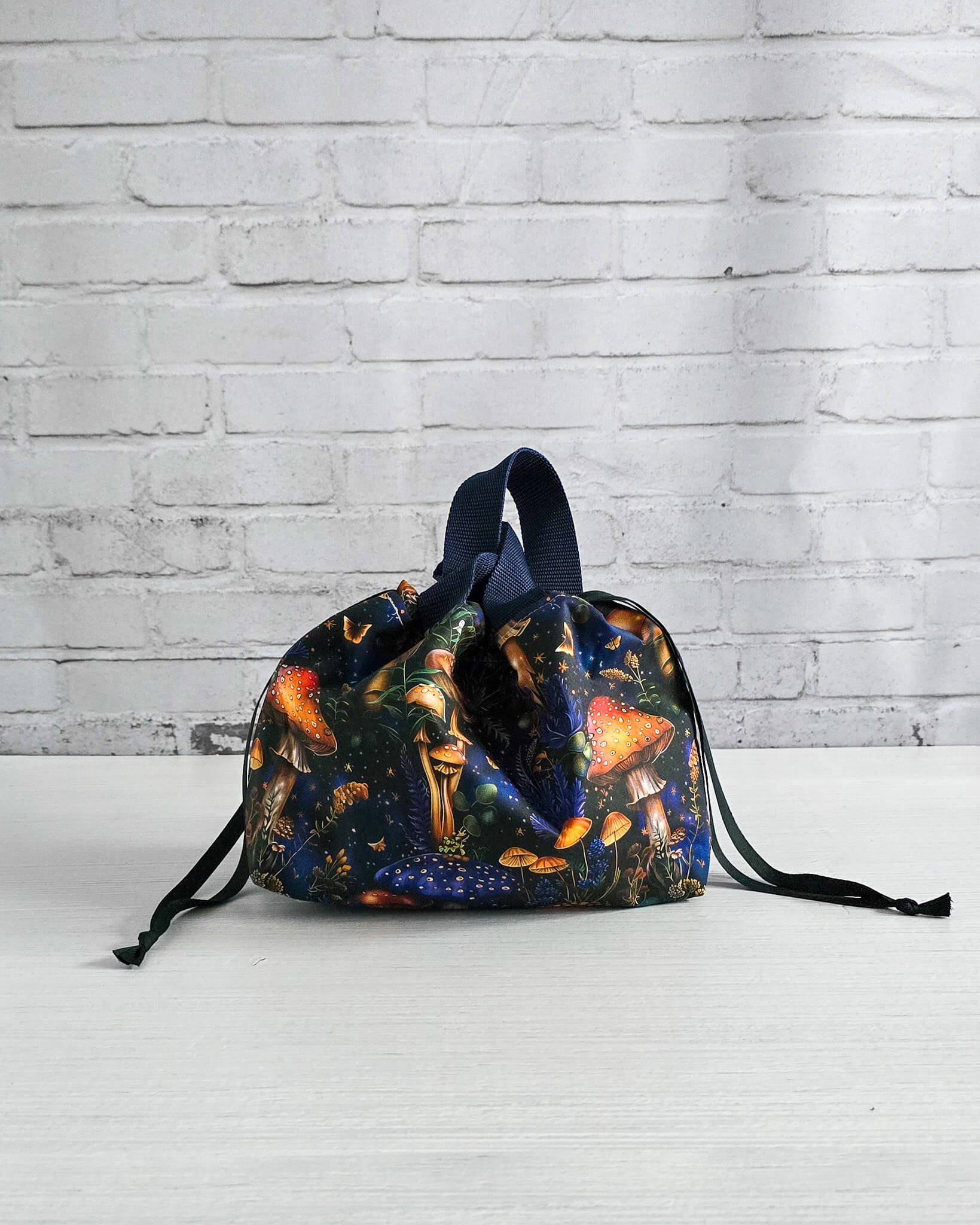 Kleine Projekttasche Alva mit Kordelzug und Henkel, Pilze auf dunklem Stoff - handgenäht in Bayern von Nadelmikado