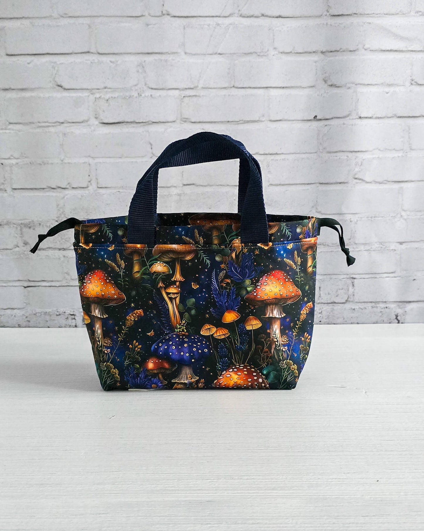 Kleine Projekttasche Alva mit Kordelzug und Henkel, Pilze auf dunklem Stoff - handgenäht in Bayern von Nadelmikado