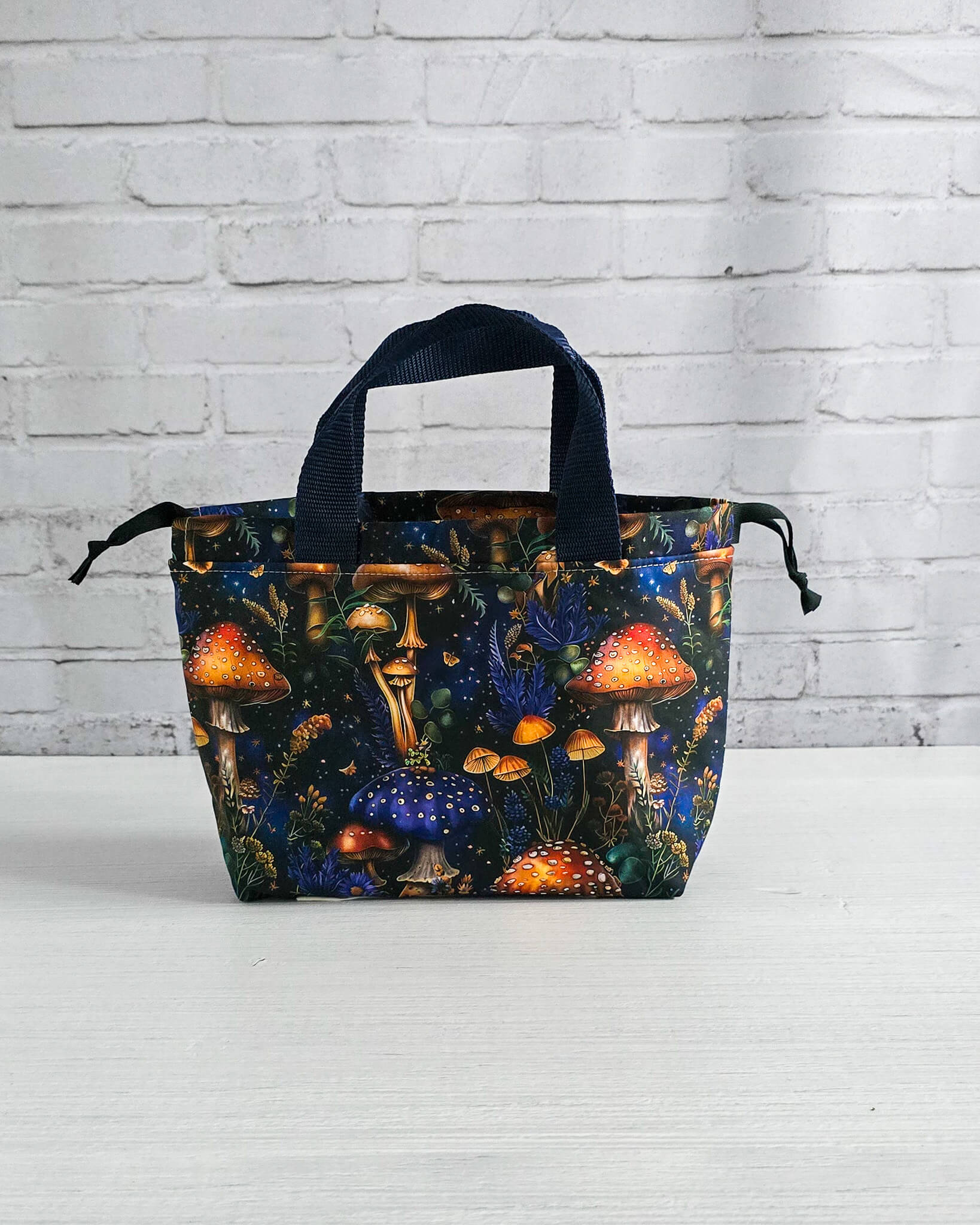 Kleine Projekttasche Alva mit Kordelzug und Henkel, Pilze auf dunklem Stoff - handgenäht in Bayern von Nadelmikado