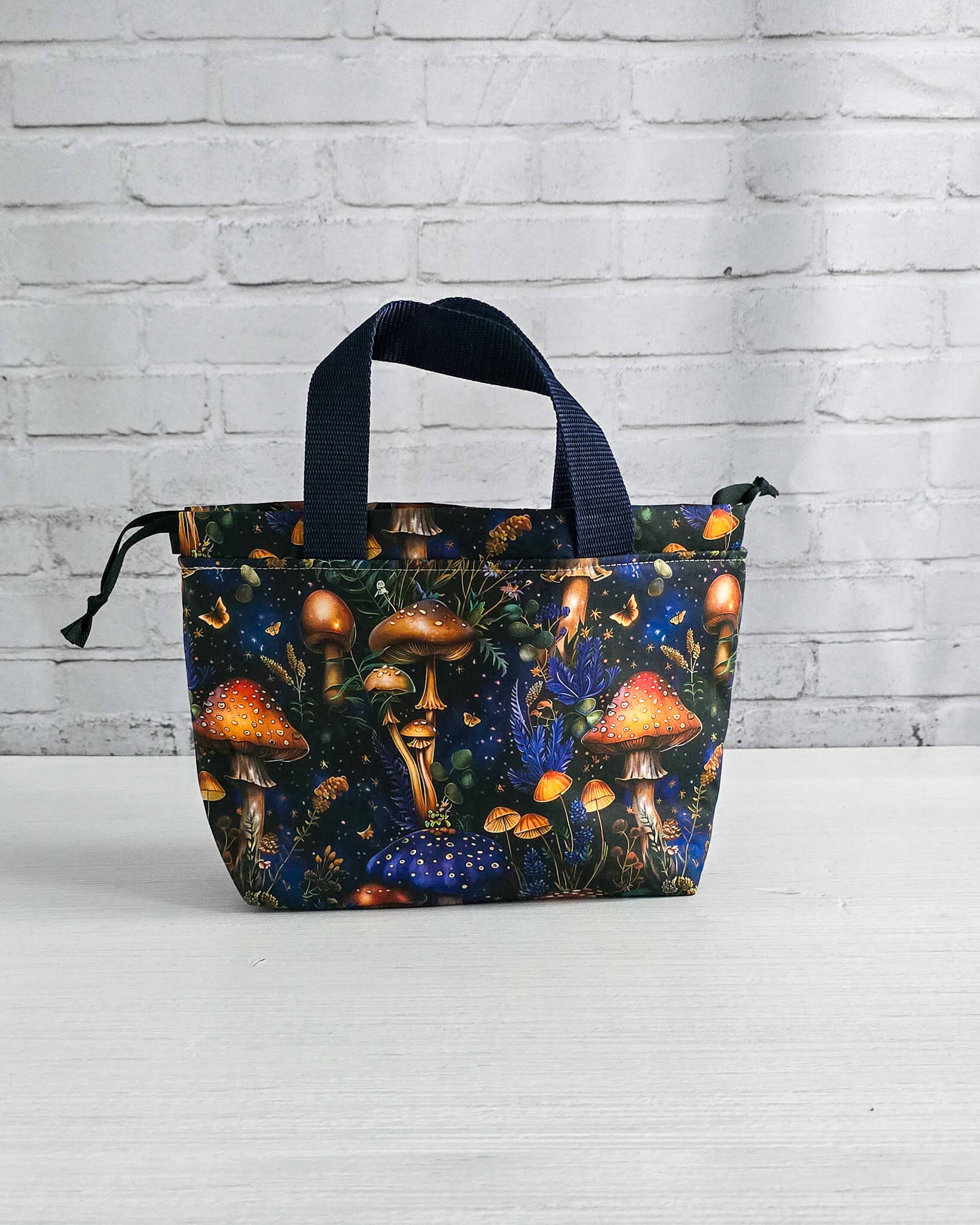 Kleine Projekttasche Alva mit Kordelzug und Henkel, Pilze auf dunklem Stoff - handgenäht in Bayern von Nadelmikado