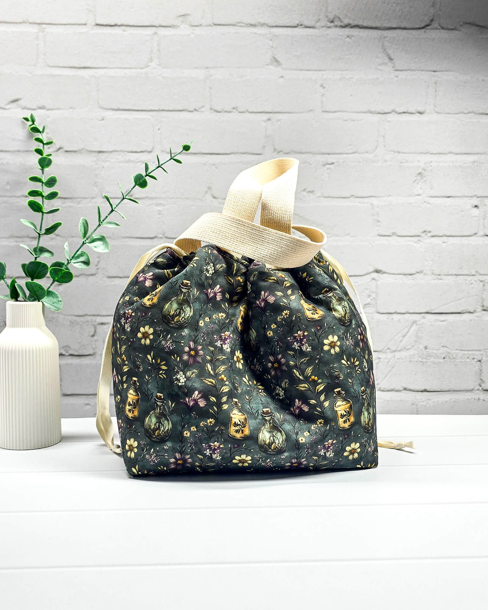 Projekttasche mit Innentaschen für bis zu 500 g Wolle im dunklen botanischen Design mit Blüten und nostalgischen Apothekerfläschchen. Handgenäht in Bayern von NadelMikado.