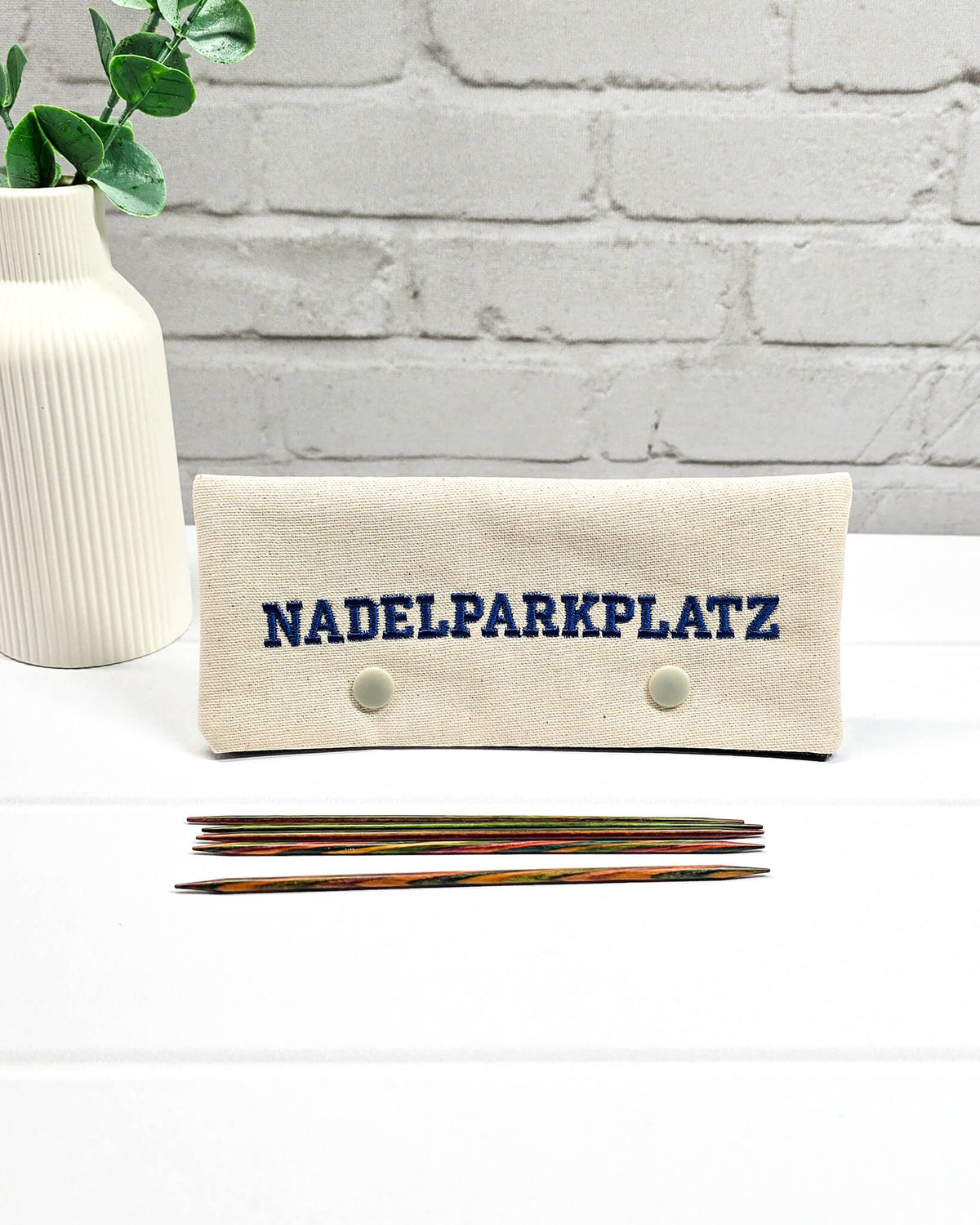 Bestickte Nadelgarage für 15 cm Nadelspiele aus hellem Stoff mit dunkelblauer Nadelparkplatz-Stickerei, handgenäht in Bayern von NadelMikado.