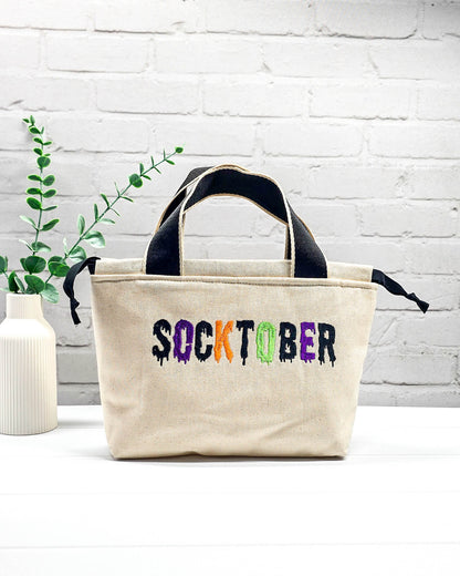 Bestickte Projekttasche Alva S aus hellem Canvas mit mehrfarbigem Socktober-Schriftzug, handgenäht in Bayern von NadelMikado