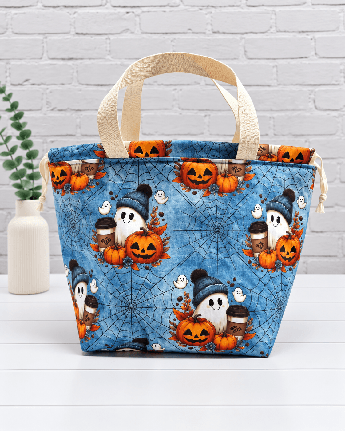 Große Stricktasche mit Geistern, Kürbissen, Kaffeebechern und Spinnennetzen auf blauem Stoff. Handgenäht in Bayern von NadelMikado.