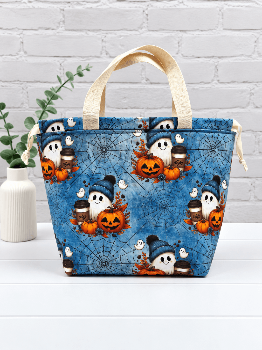 Große Stricktasche mit Geistern, Kürbissen, Kaffeebechern und Spinnennetzen auf blauem Stoff. Handgenäht in Bayern von NadelMikado.