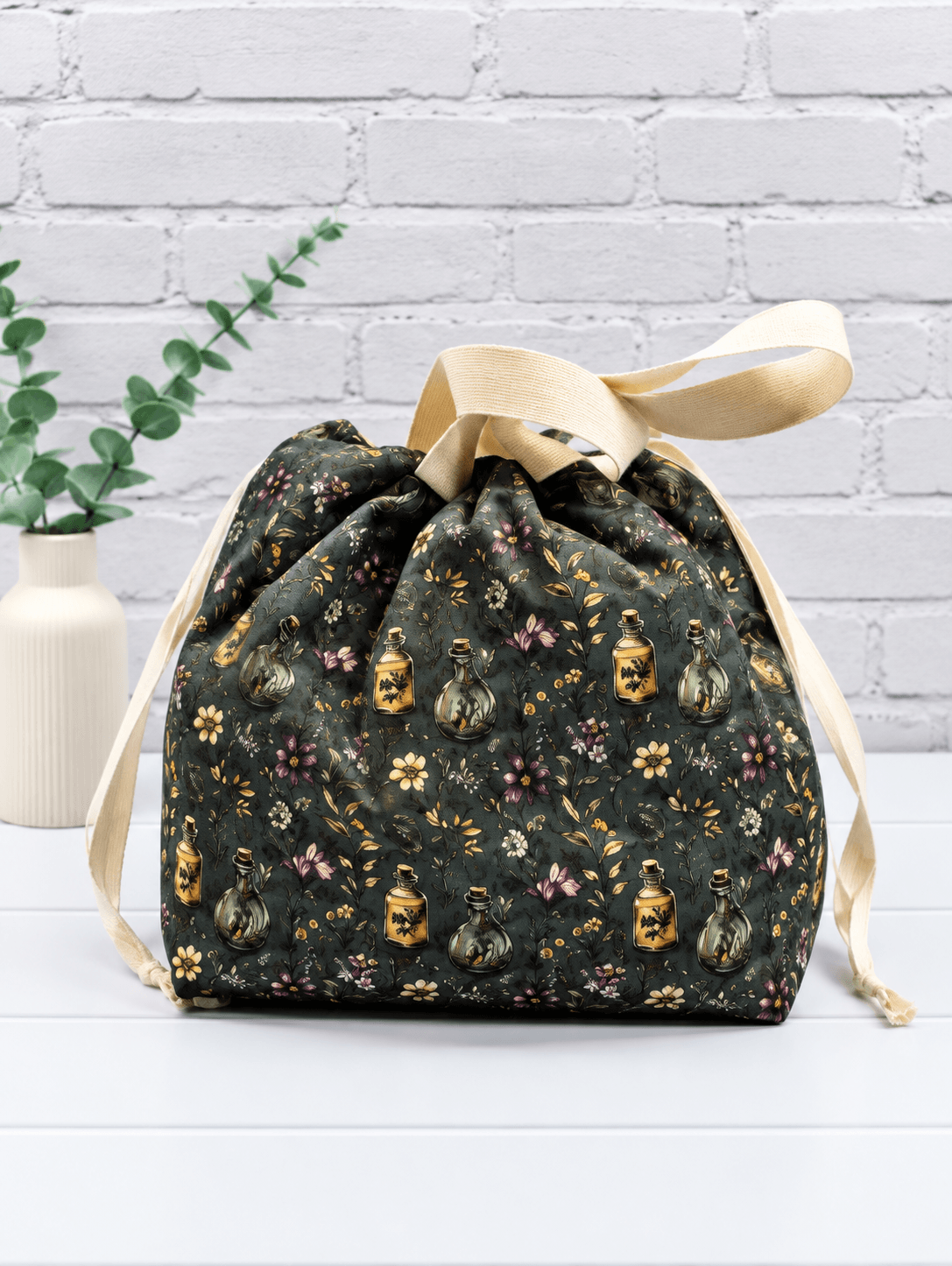 Große Projekttasche mit Blüten, Zweigen und kleinen Apothekerfläschchen auf dunklem Stoff. Handgenäht in Bayern von NadelMikado.