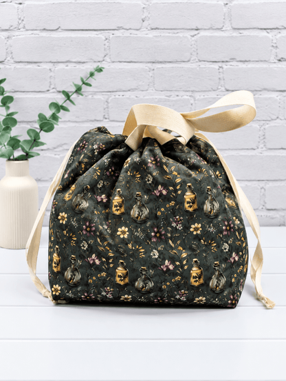 Große Projekttasche mit Blüten, Zweigen und kleinen Apothekerfläschchen auf dunklem Stoff. Handgenäht in Bayern von NadelMikado.