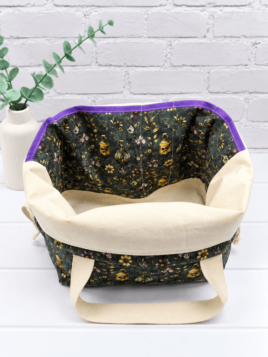Große Projekttasche mit Blüten, Zweigen und kleinen Apothekerfläschchen auf dunklem Stoff. Handgenäht in Bayern von NadelMikado.
