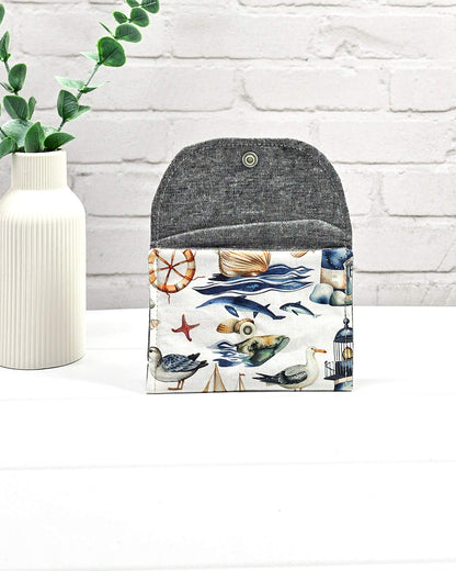 Mini Pouch mit einem maritimen Muster aus Möwen, Segelbooten und Leuchttürmen, geschwungener Klappe und einem hellen Druckknopf. Handgenäht in Bayern von Nadelmikado