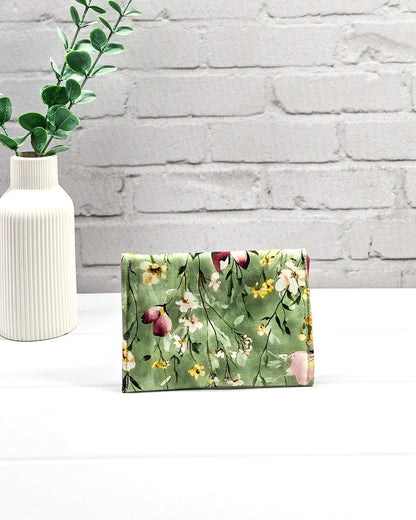 Kleine Mini Pouch mit buntem Wildblumenmotiv auf salbeigrünem Grund und einem hellgrauen Druckknopf. Handgenäht in Bayern von Nadelmikado.