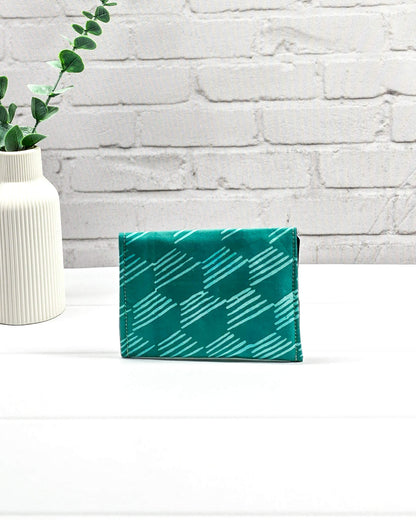 Kleine, flache Mini-Pouch für Strickzubehör mit hellem, grafischem Linienmuster auf smaragdgrünem Stoff, verschlossen mit einer Klappe und einem schwarzen Druckknopf. Handgenäht in Bayern von Nadelmikado.