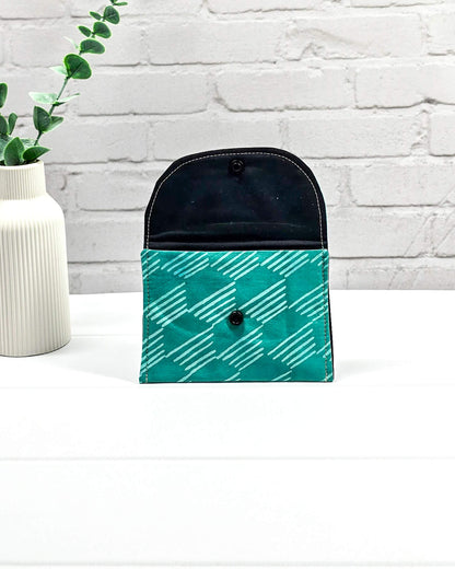 Kleine, flache Mini-Pouch für Strickzubehör mit hellem, grafischem Linienmuster auf smaragdgrünem Stoff, verschlossen mit einer Klappe und einem schwarzen Druckknopf. Handgenäht in Bayern von Nadelmikado.