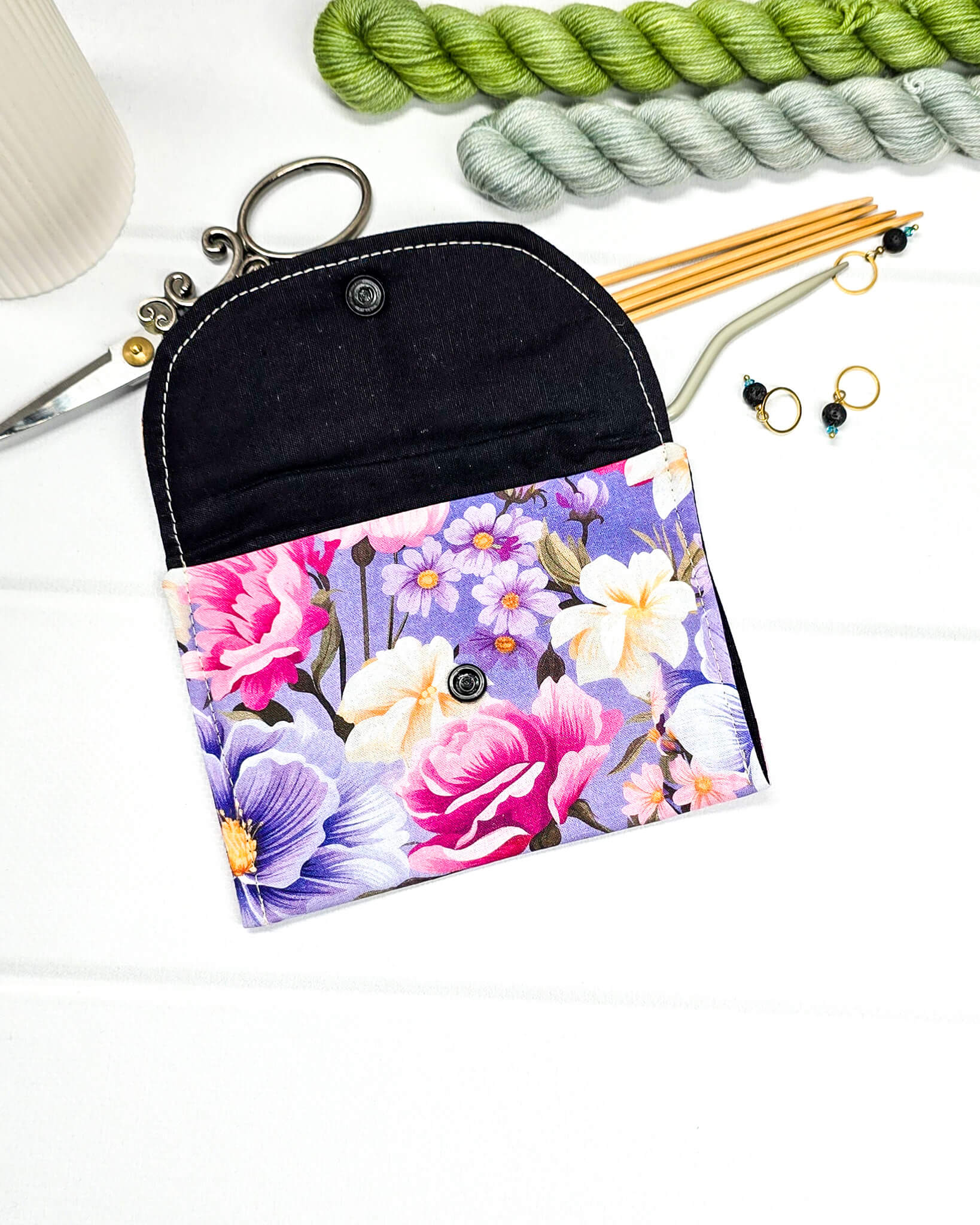 Kleine, flache Mini-Pouch für Strickzubehör mit üppigem Rosen- und Blütenmuster in Magenta und Lila, verschlossen mit einer Klappe und einem schwarzen Druckknopf. Handgenäht in Bayern von Nadelmikado