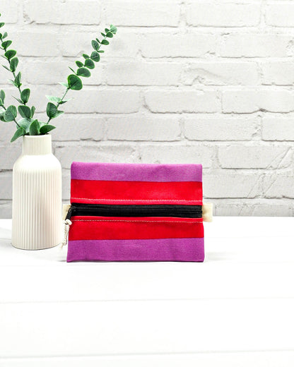 Mini Zip Pouch mit breiten horizontalen Streifen in Rot und Violett, einem schwarzen mittigen Reißverschluss und hellen Stofflaschen. Handgenäht in Bayern von Nadelmikado