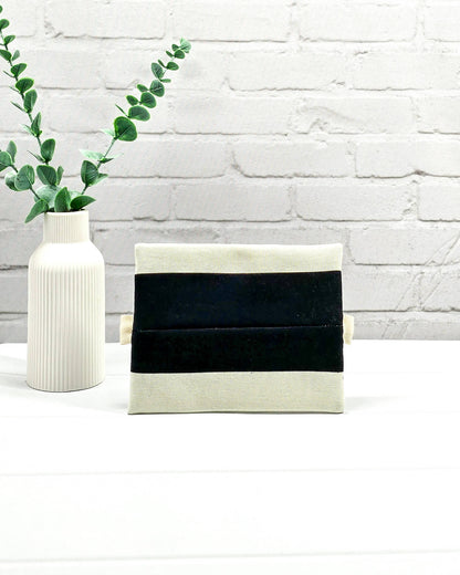 Mini Zip Pouch mit breiten horizontalen Streifen in Schwarz und Creme, einem schwarzen mittigen Reißverschluss und hellen Stofflaschen. Handgenäht in Bayern von Nadelmikado. 