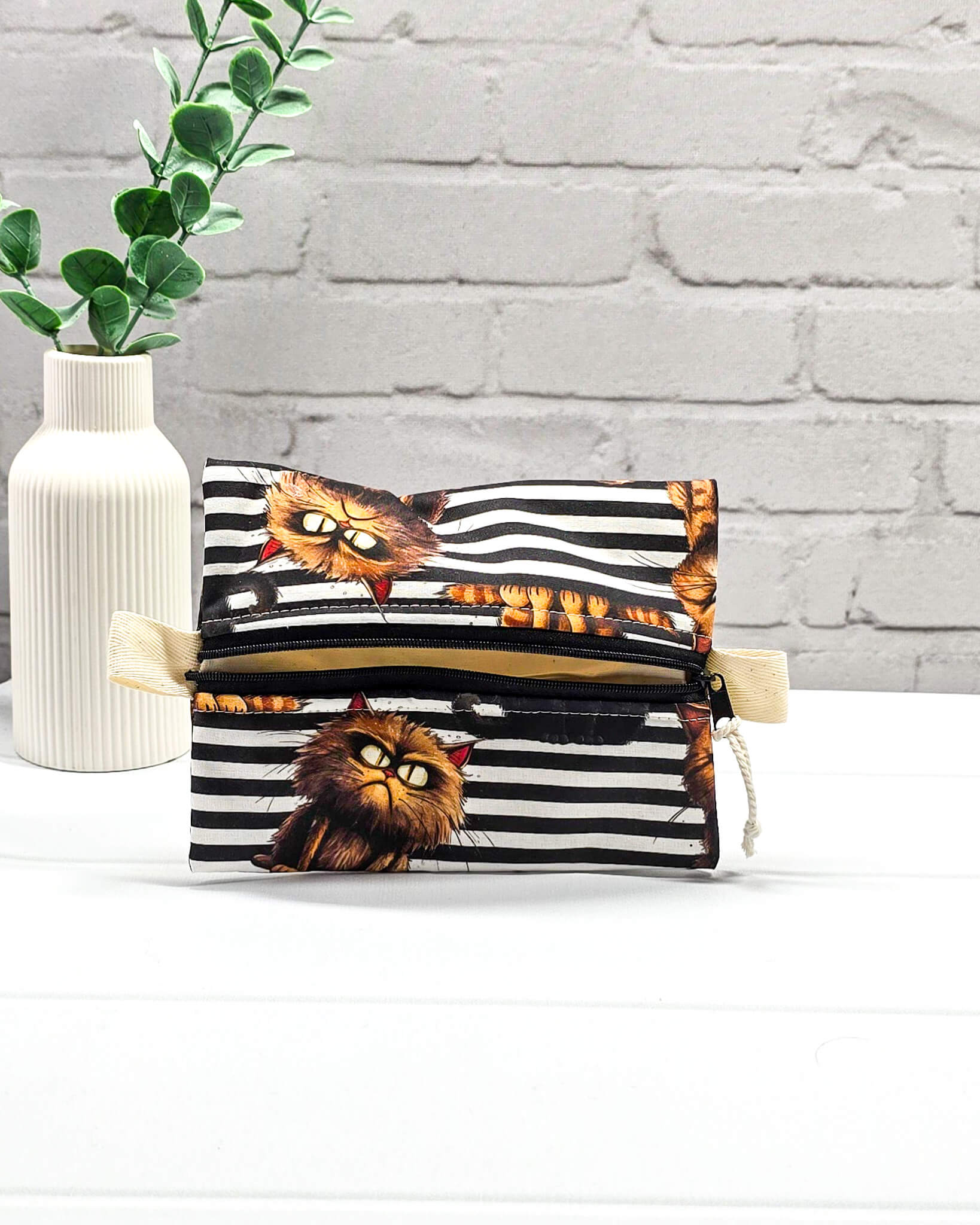 Kleine Zubehörtasche mit schwarz-weißem Streifenmuster, Grumpy-Cat-Motiven und einem Reißverschluss. Handgenäht in Bayern von Nadelmikado.