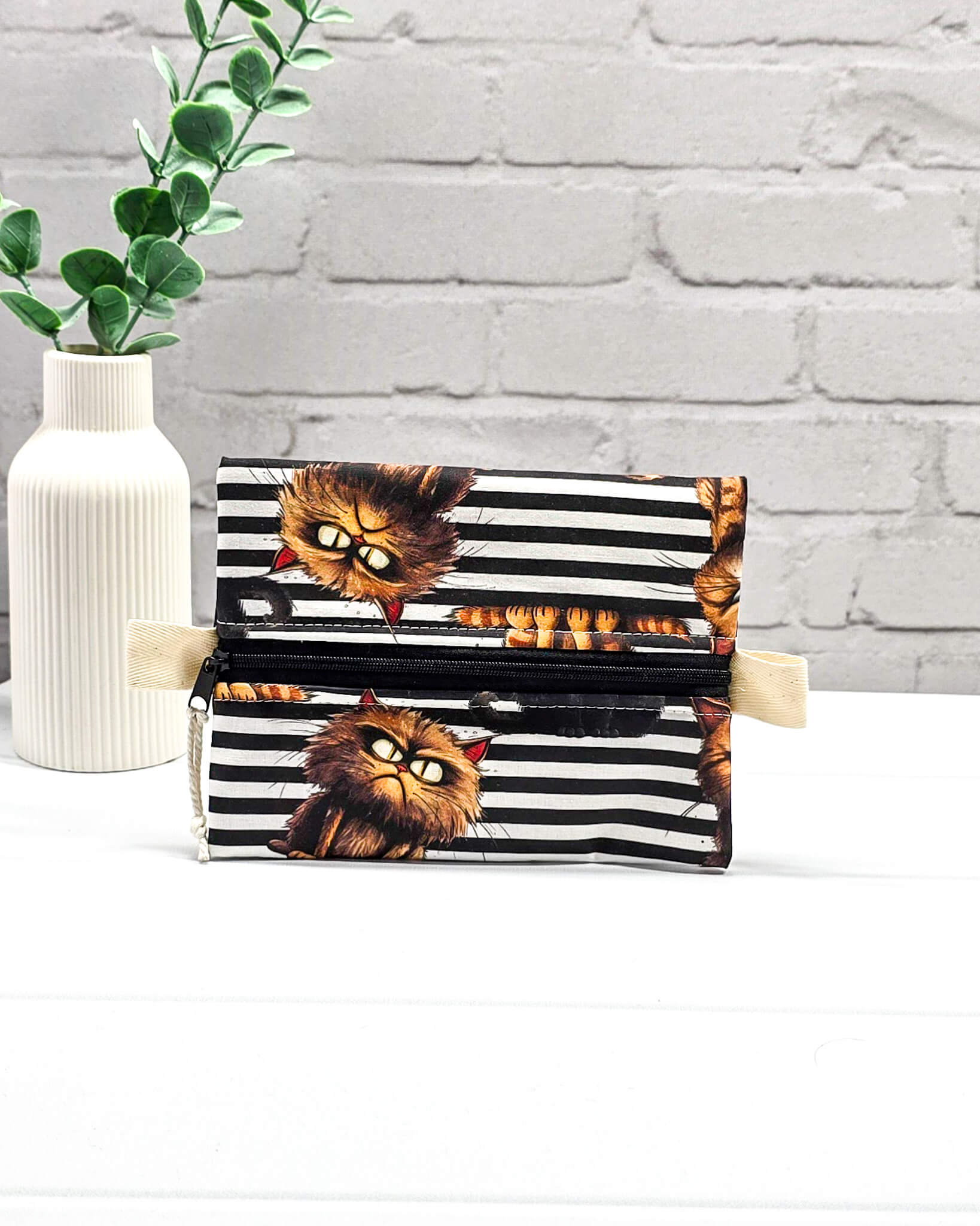 Kleine Zubehörtasche mit schwarz-weißem Streifenmuster, Grumpy-Cat-Motiven und einem Reißverschluss. Handgenäht in Bayern von Nadelmikado.