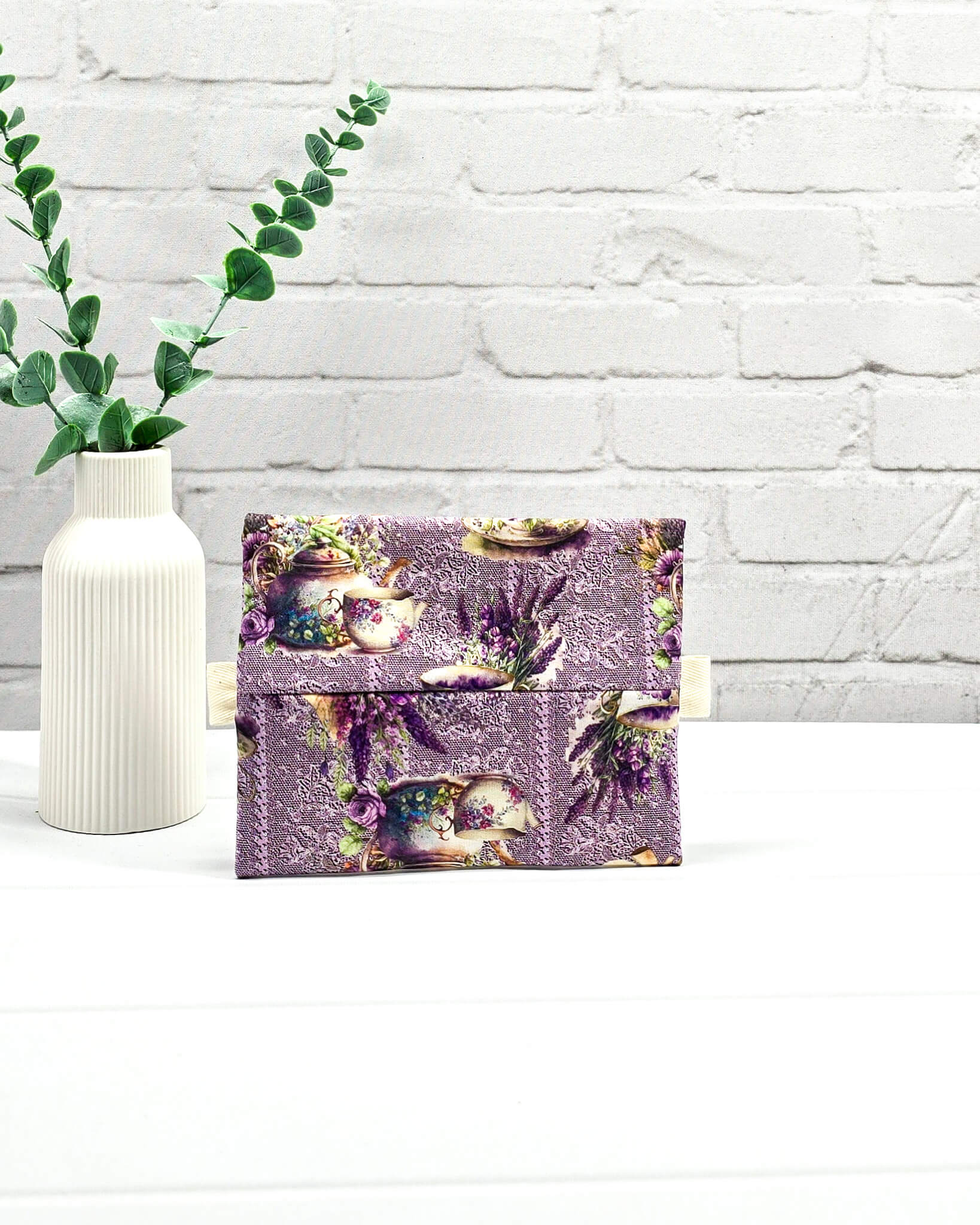 Mini Zip Pouch mit einem lila Lavendel- und Teetassen-Muster, einem hellvioletten mittigen Reißverschluss und hellen Stofflaschen. Handgenäht in Bayern von Nadelmikado. 