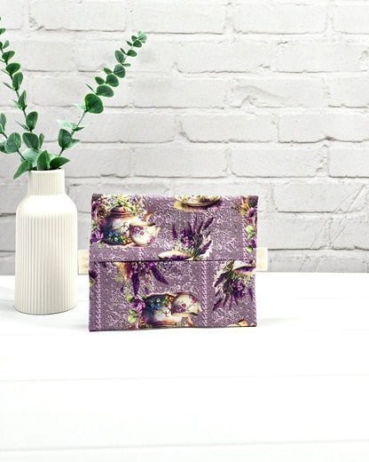 Mini Zip Pouch mit einem lila Lavendel- und Teetassen-Muster, einem hellvioletten mittigen Reißverschluss und hellen Stofflaschen. Handgenäht in Bayern von Nadelmikado. 