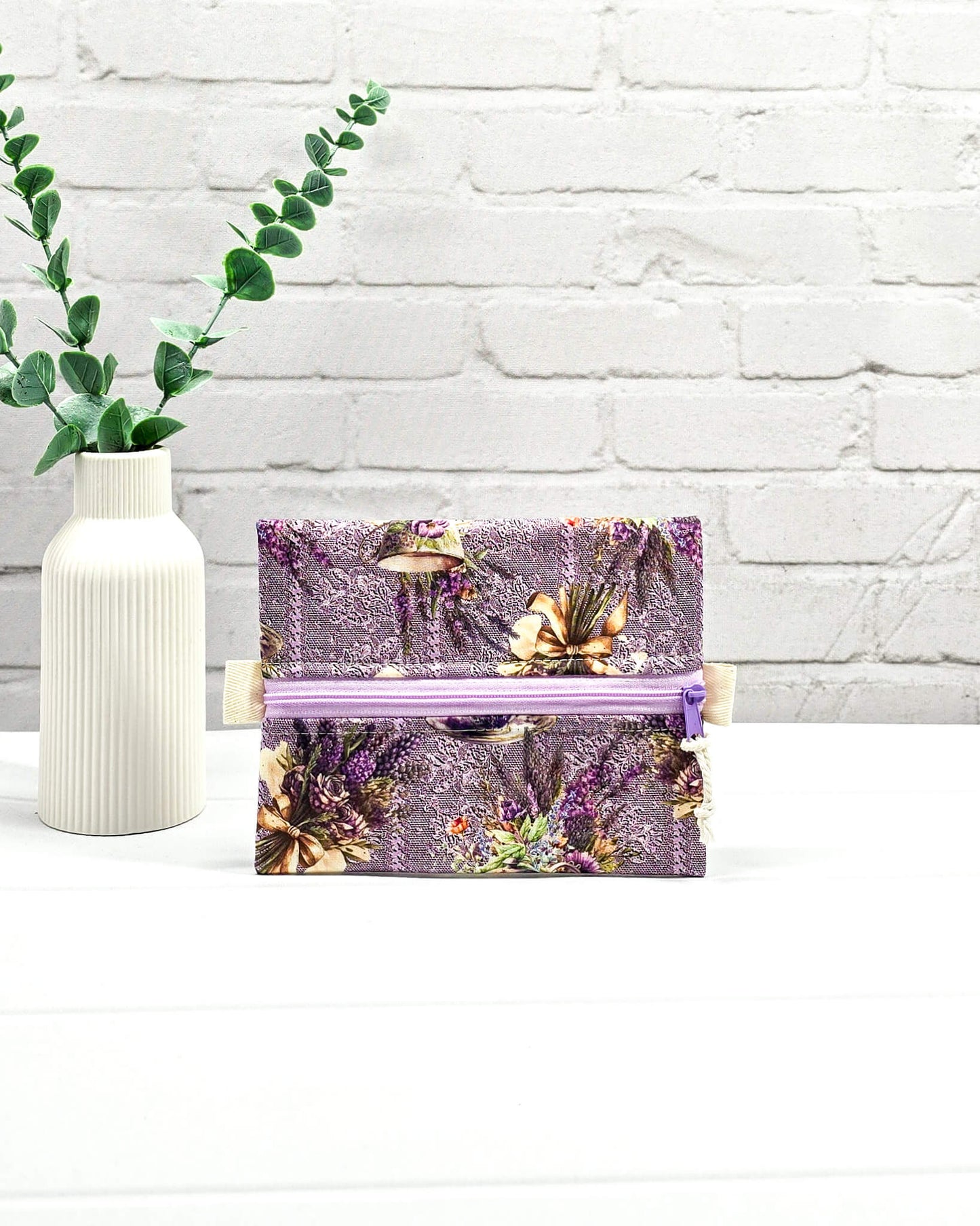 Mini Zip Pouch mit einem lila Lavendel- und Teetassen-Muster, einem hellvioletten mittigen Reißverschluss und hellen Stofflaschen. Handgenäht in Bayern von Nadelmikado. 
