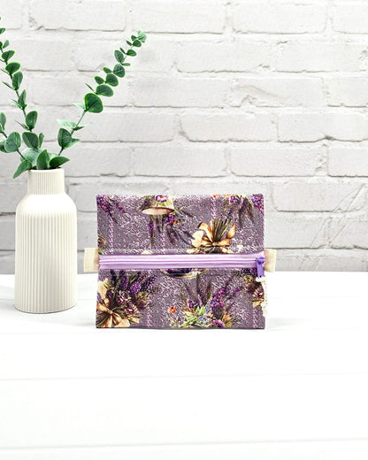 Mini Zip Pouch mit einem lila Lavendel- und Teetassen-Muster, einem hellvioletten mittigen Reißverschluss und hellen Stofflaschen. Handgenäht in Bayern von Nadelmikado. 