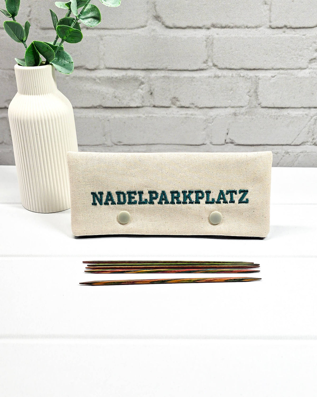 Nadelgarage für 15 cm Nadelspiele aus hellem Stoff mit Nadelparkplatz-Stickerei in Petrol, handgenäht in Bayern von NadelMikado.
