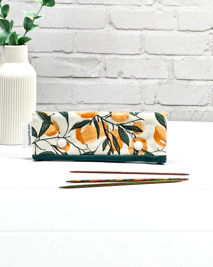 Nadelgarage für 15 cm lange Nadelspiele sichert das Sockenstrickzeug und verhindert fallengelassene Maschen. Botanisches Motiv mit Orangen an grünen Zweigen auf hellem Stoff. Handgenäht in Bayern von Nadelmikado.