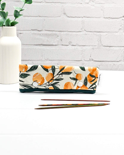 Nadelgarage für 15 cm lange Nadelspiele sichert das Sockenstrickzeug und verhindert fallengelassene Maschen. Botanisches Motiv mit Orangen an grünen Zweigen auf hellem Stoff. Handgenäht in Bayern von Nadelmikado.