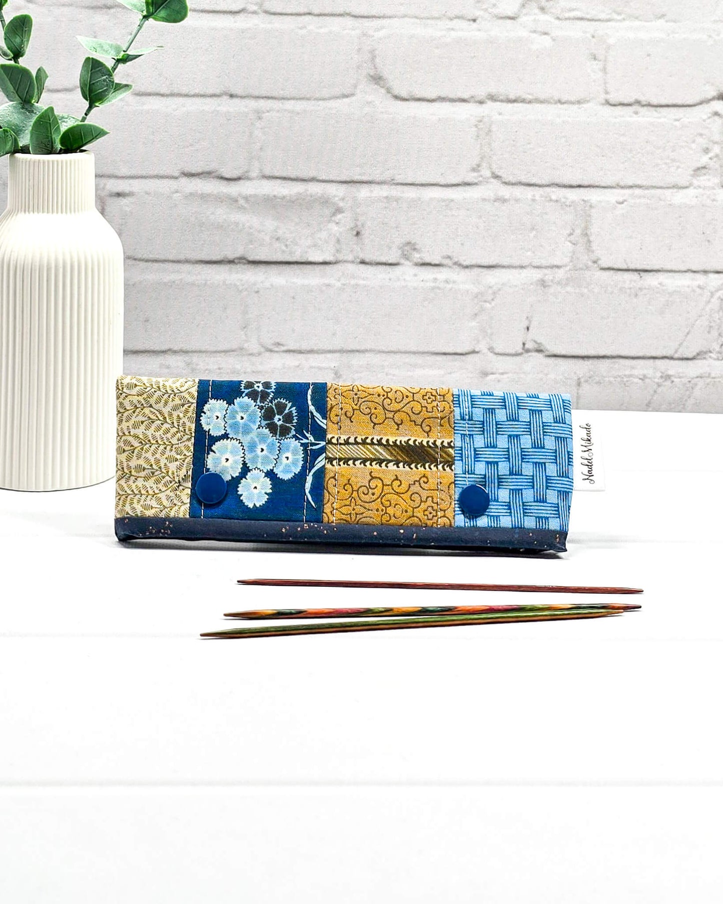 Nadelgarage für 15 cm lange Nadelspiele hält das Sockenstrickzeug zusammen und verhindert fallengelassene Maschen. Elegantes Vintage-Motiv mit blauen Blüten und ockerfarbenen Ornamenten. Handgenäht in Bayern von Nadelmikado. 