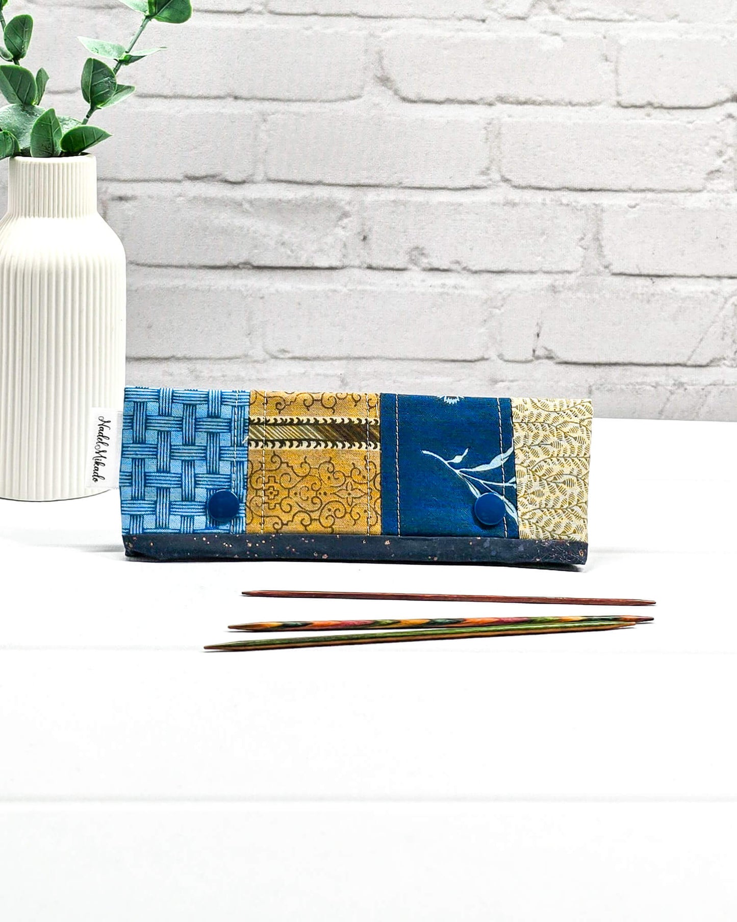 Nadelgarage für 15 cm lange Nadelspiele hält das Sockenstrickzeug zusammen und verhindert fallengelassene Maschen. Elegantes Vintage-Motiv mit blauen Blüten und ockerfarbenen Ornamenten. Handgenäht in Bayern von Nadelmikado. 