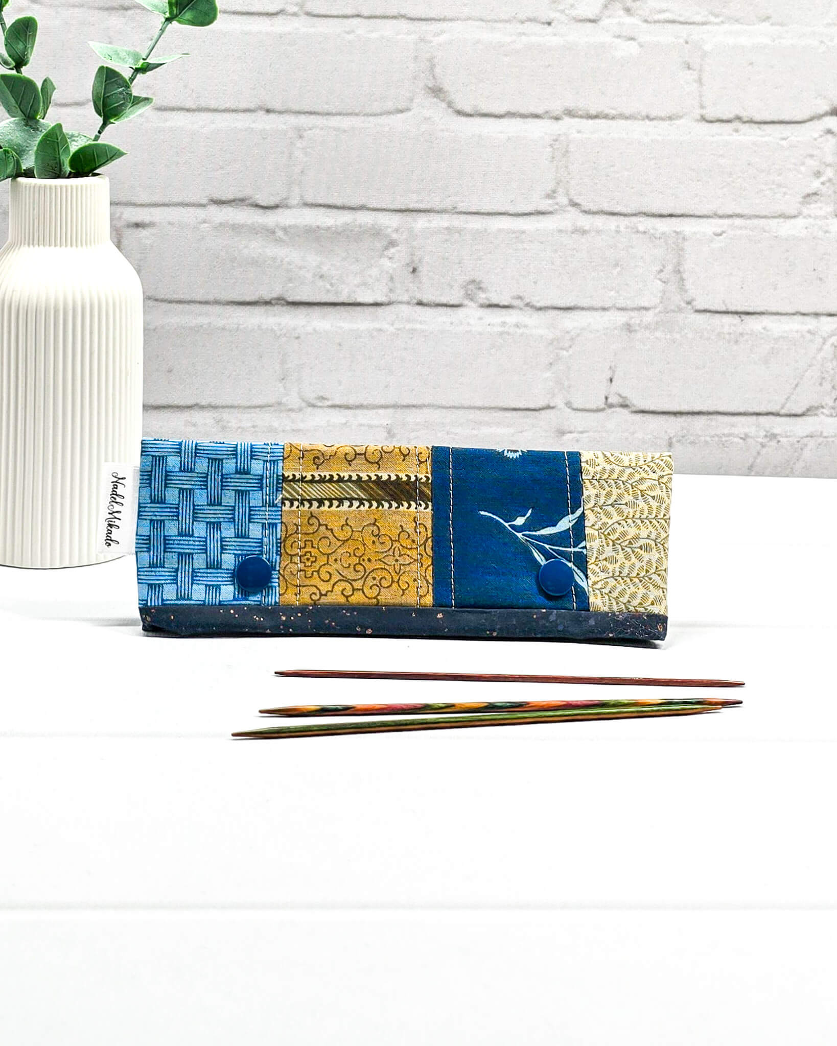 Nadelgarage für 15 cm lange Nadelspiele hält das Sockenstrickzeug zusammen und verhindert fallengelassene Maschen. Elegantes Vintage-Motiv mit blauen Blüten und ockerfarbenen Ornamenten. Handgenäht in Bayern von Nadelmikado. 