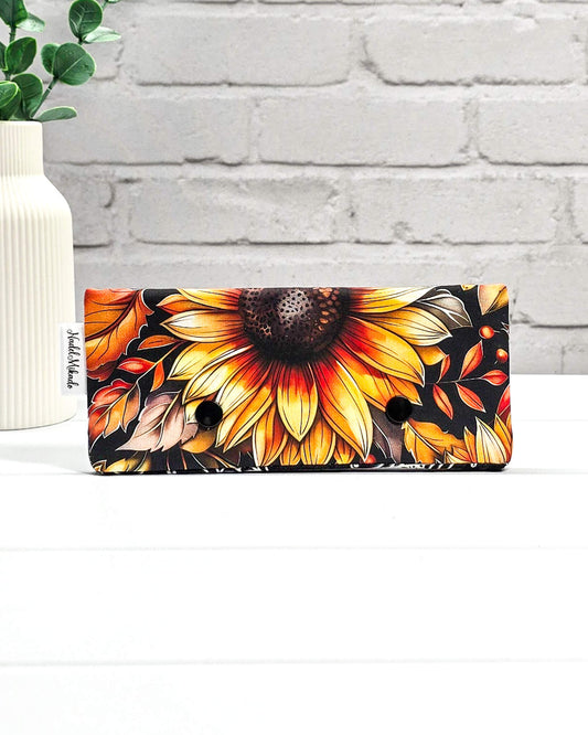 Nadelgarage für 15 cm lange Nadelspiele mit zwei schwarzen Druckknöpfen und großem Sonnenblumen-Motiv auf dunklem Grund. Handgenäht in Bayern von Nadelmikado.