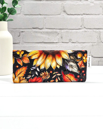 Nadelgarage für 15 cm lange Nadelspiele mit zwei schwarzen Druckknöpfen und großem Sonnenblumen-Motiv auf dunklem Grund. Handgenäht in Bayern von Nadelmikado.