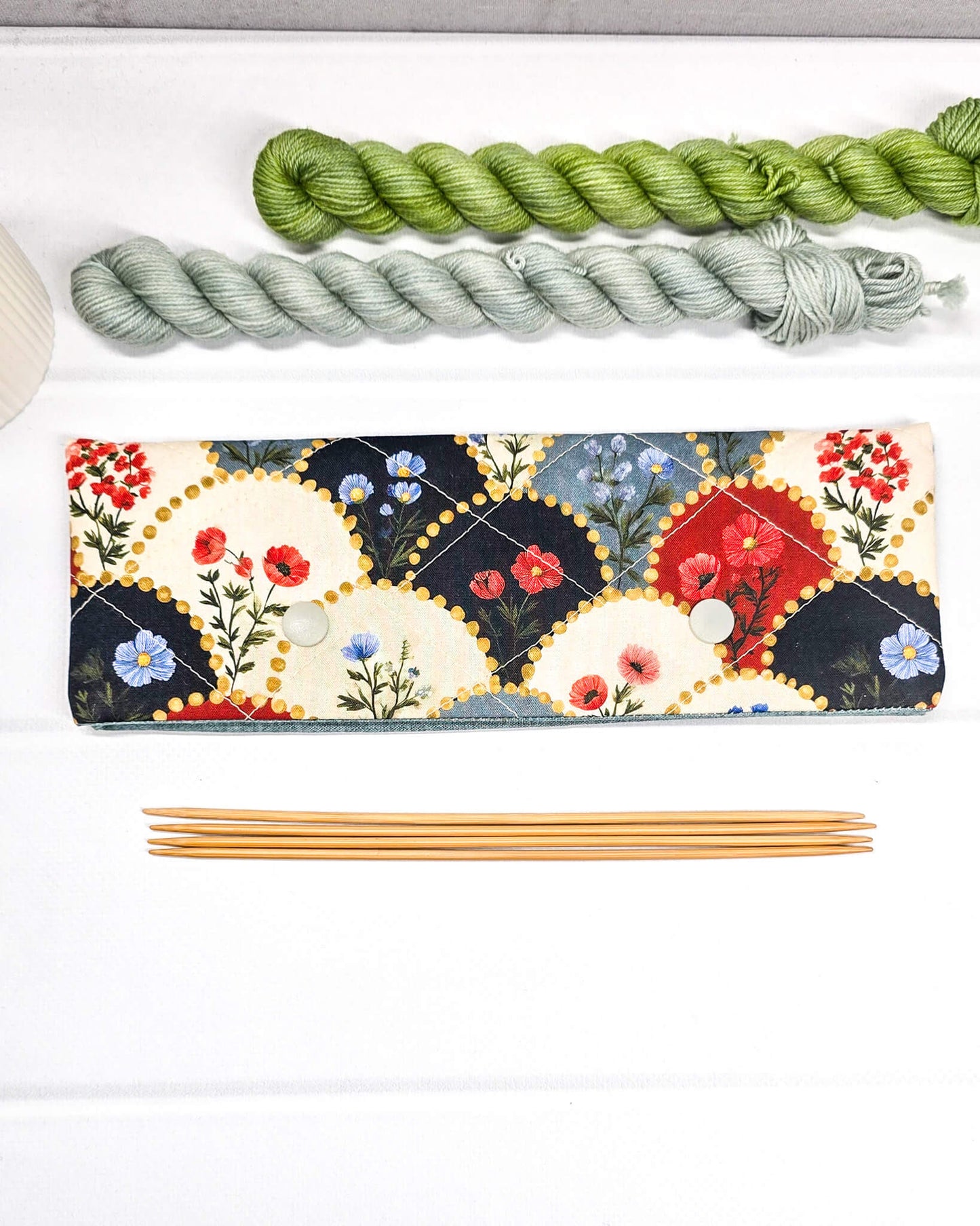 Nadelgarage für 20 cm Nadelspiele mit einem Muster aus Rauten, die rote und blaue Blumen auf cremefarbenem und dunkelblauem Grund zeigen - handgenäht in Bayern von Nadelmikado