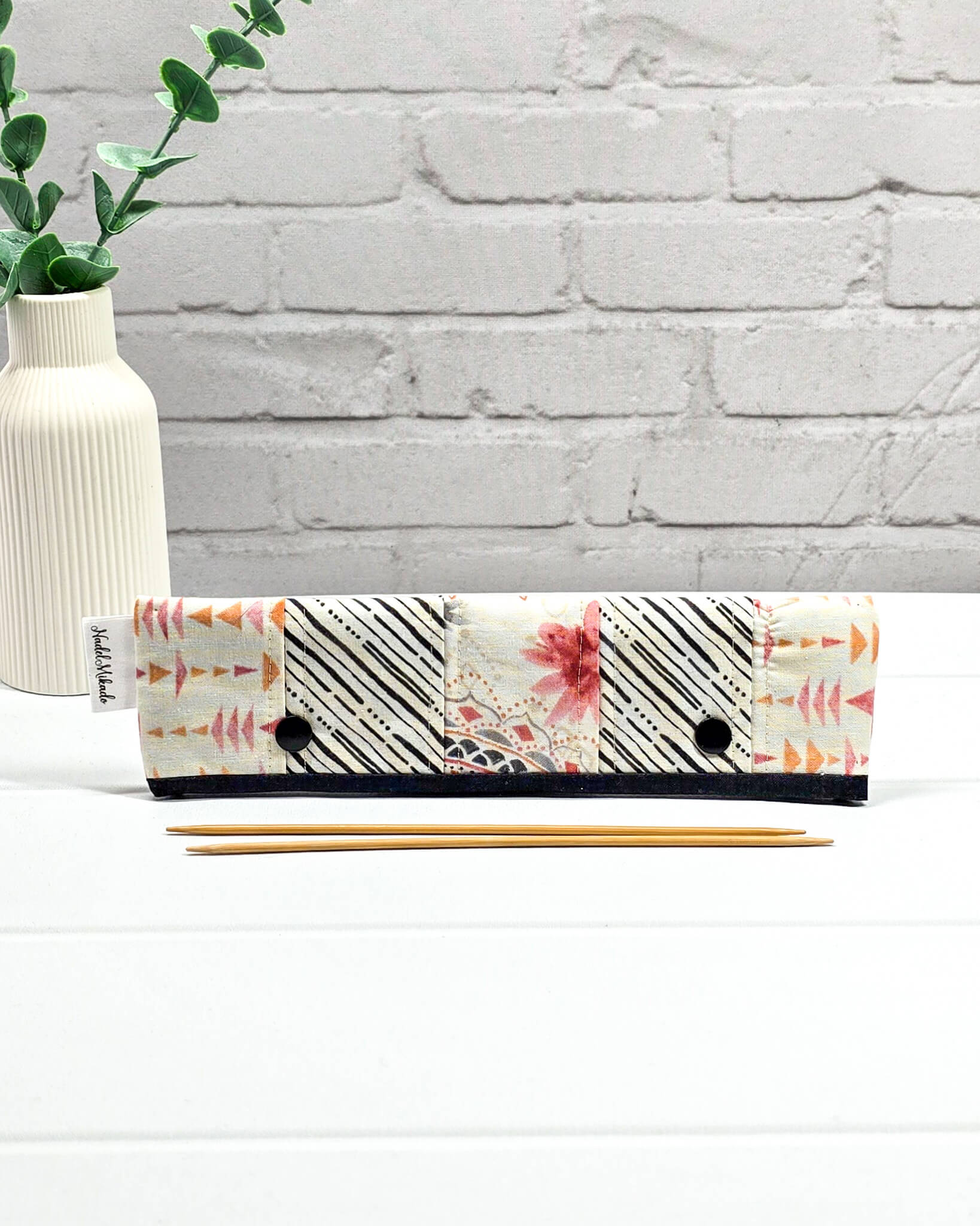 Nadelgarage für 20 cm Nadelspiele im Patchwork-Design mit Ethno-Mustern, Streifen und Dreiecken sowie zwei schwarzen Druckknöpfen. Handgenäht in Bayern von Nadelmikado