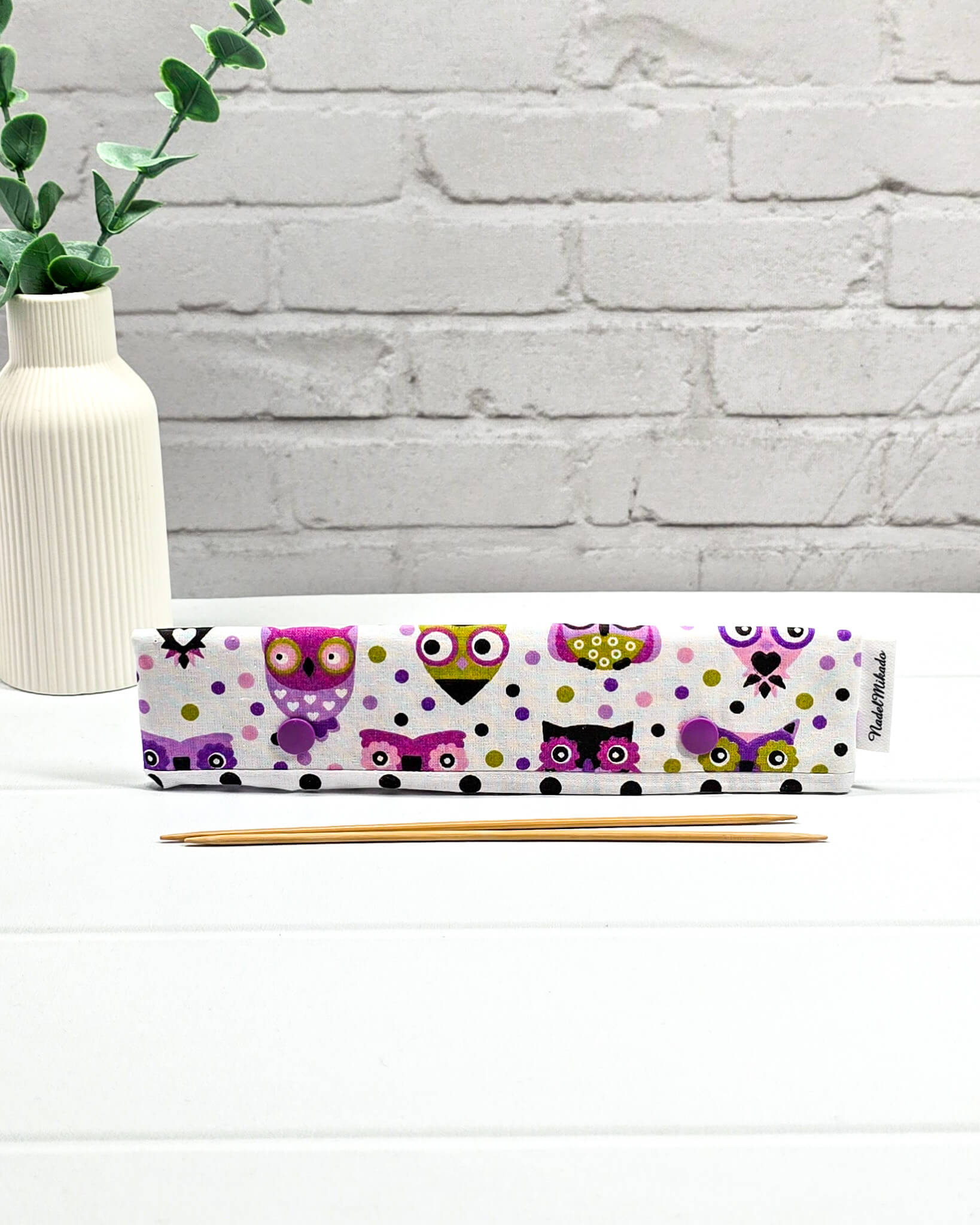 Nadelgarage für 20 cm Nadelspiele mit bunten Eulen-Motiven, lila Druckknöpfen und schwarz-weiß gepunktetem Hintergrund. Handgenäht in Bayern von Nadelmikado