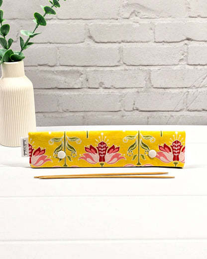Nadelgarage für 20 cm Nadelspiele mit symmetrischen rosa-roten Blüten auf gelbem Stoff und zwei weißen Druckknöpfen. Handgenäht in Bayern von Nadelmikado