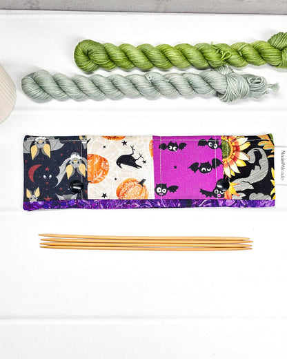 Nadelgarage für 20 cm Nadelspiele im Patchwork-Design mit Totenköpfen, Spinnennetzen auf Orange und floralen Mustern sowie schwarzen Druckknöpfen. Handgenäht in Bayern von Nadelmikado.