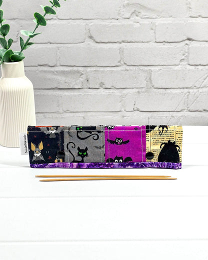 Nadelgarage für 20 cm Nadelspiele im Patchwork-Look mit Spinnennetzen, Totenköpfen, einer schwarzen Katze und Halloween-Kürbissen sowie schwarzen Druckknöpfen. Handgenäht in Bayern von Nadelmikado.